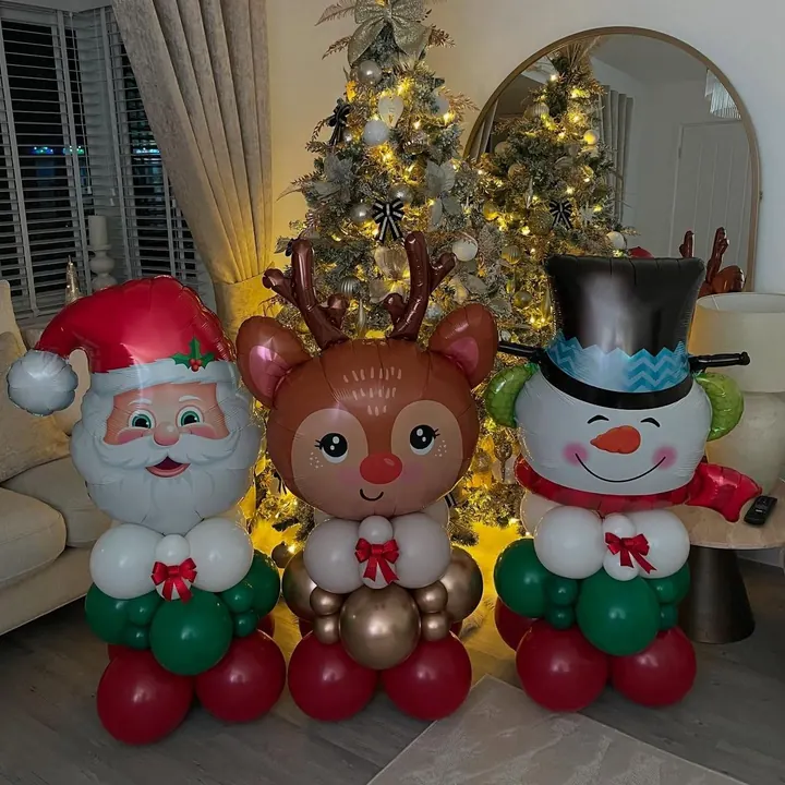 Father Christmas, reindeer and snowman balloon figures beside a Christmas tree