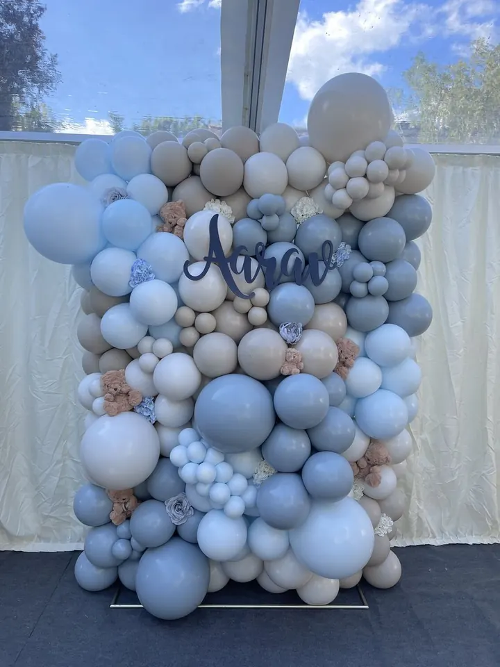 Dusty blue, grey and cream balloon wall with a personalised name sign