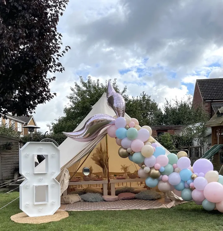 Garden teepee with a pastel balloon garland, a mermaid tail balloon and a light-up 8