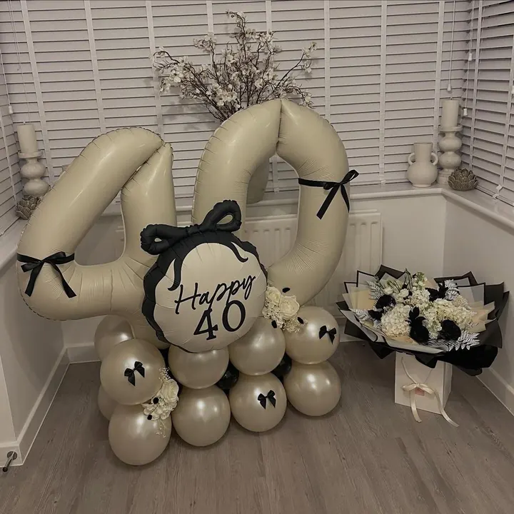 Champagne balloon 40 numbers with black bows and a Happy 40 balloon