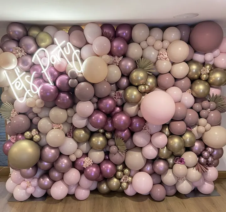 Full balloon wall in mauve, pink, gold and chrome with a Let's Party neon sign