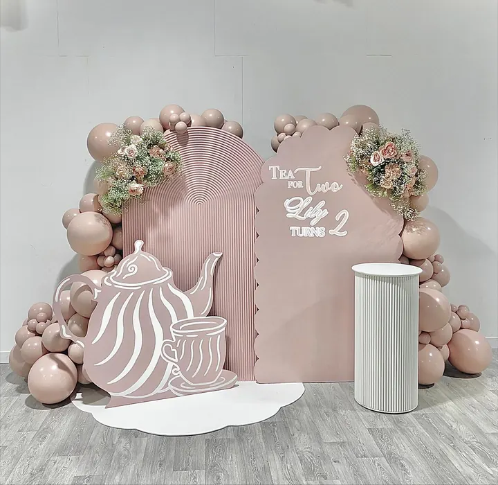 Tea for Two backdrop with a teapot cut-out, blush balloons and pink florals for a second birthday
